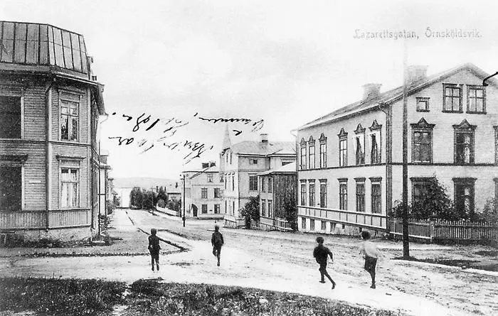 Fyra pojkar springer längst gatorna inne i staden, fotografi i svarttvitt