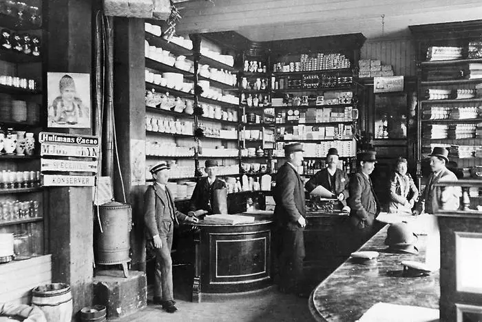 Bilden visar kunder inuti en butik med högt i tak, foto i svarttvitt